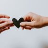 two person holding papercut heart