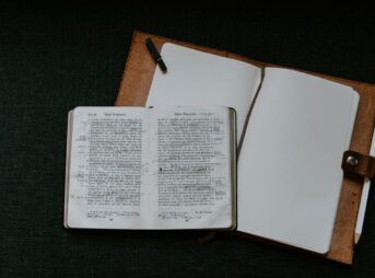 hardbound book on top of brown binder